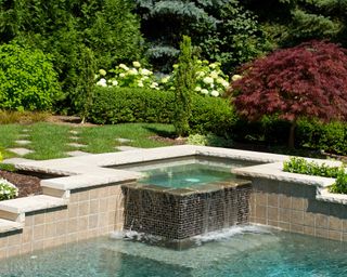 hot tub near pool surrounded by wall