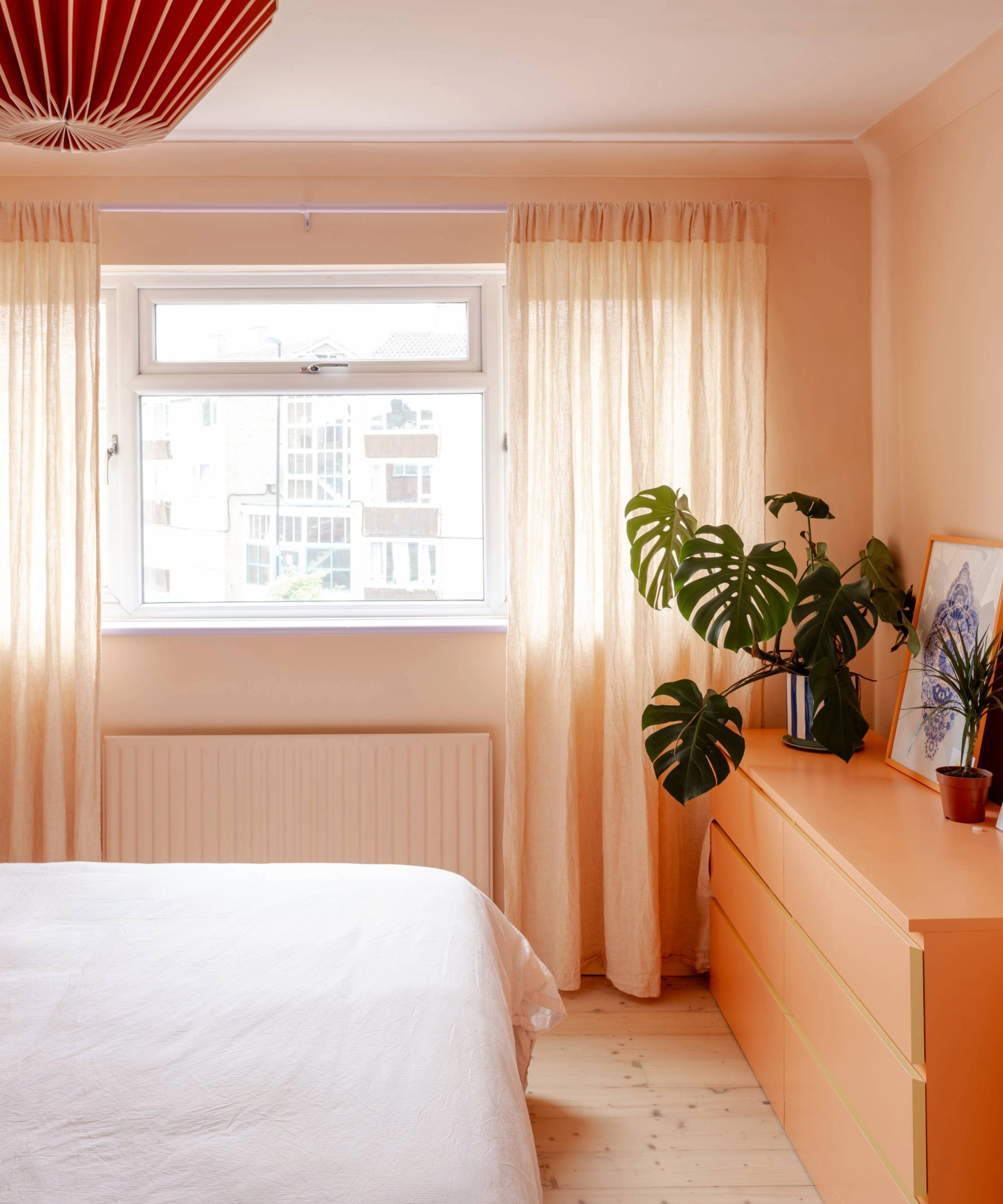 Bedroom with salmon pink colour scheme and plant