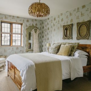guest bedroom with chandelier and wallpaper on wall