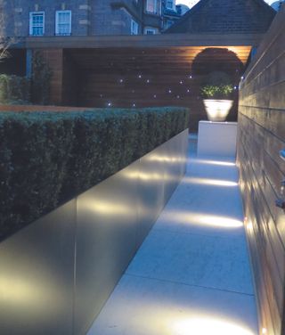 How to position landscape lighting in a modern garden with a box hedge and lighting illuminated pathway