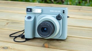 A Fujifilm Instax Wide 400 instant camera in the sage green colorway