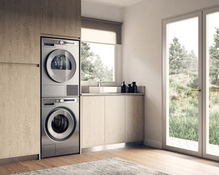 Two freestanding washing machines in a bright and spacious laundry room with full-length window