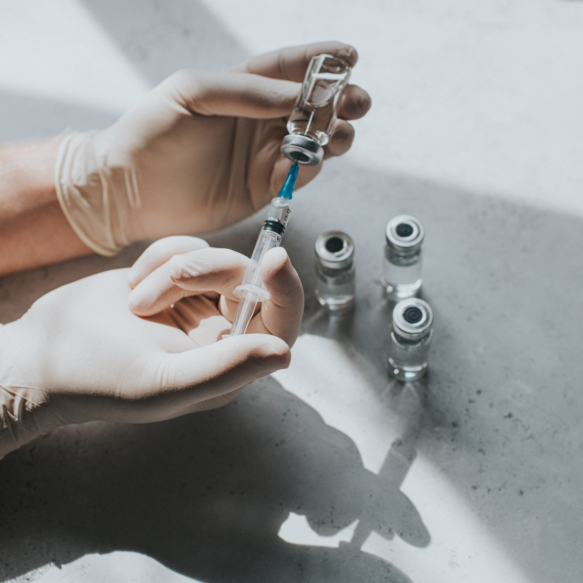 Where to get Botox: Gloved hand holds a syringe and a phial - Conceptual medical image 