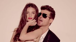 Robin Thicke and Emily Ratajkowski dance close in "Blurred Lines" music video