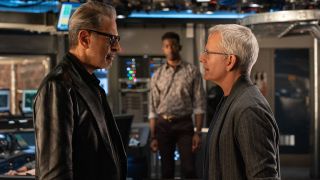 Jeff Goldblum and Campbell Scott talk while Mamoudou Athie watches in Jurassic World Dominion.