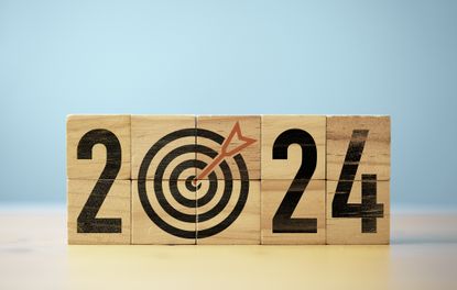 2024 written on wooden blocks with bullseye for the zero and an arrow in the middle