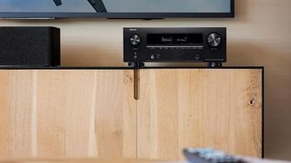Denon AVR-X2800H home cinema amplifier on a wood media unit