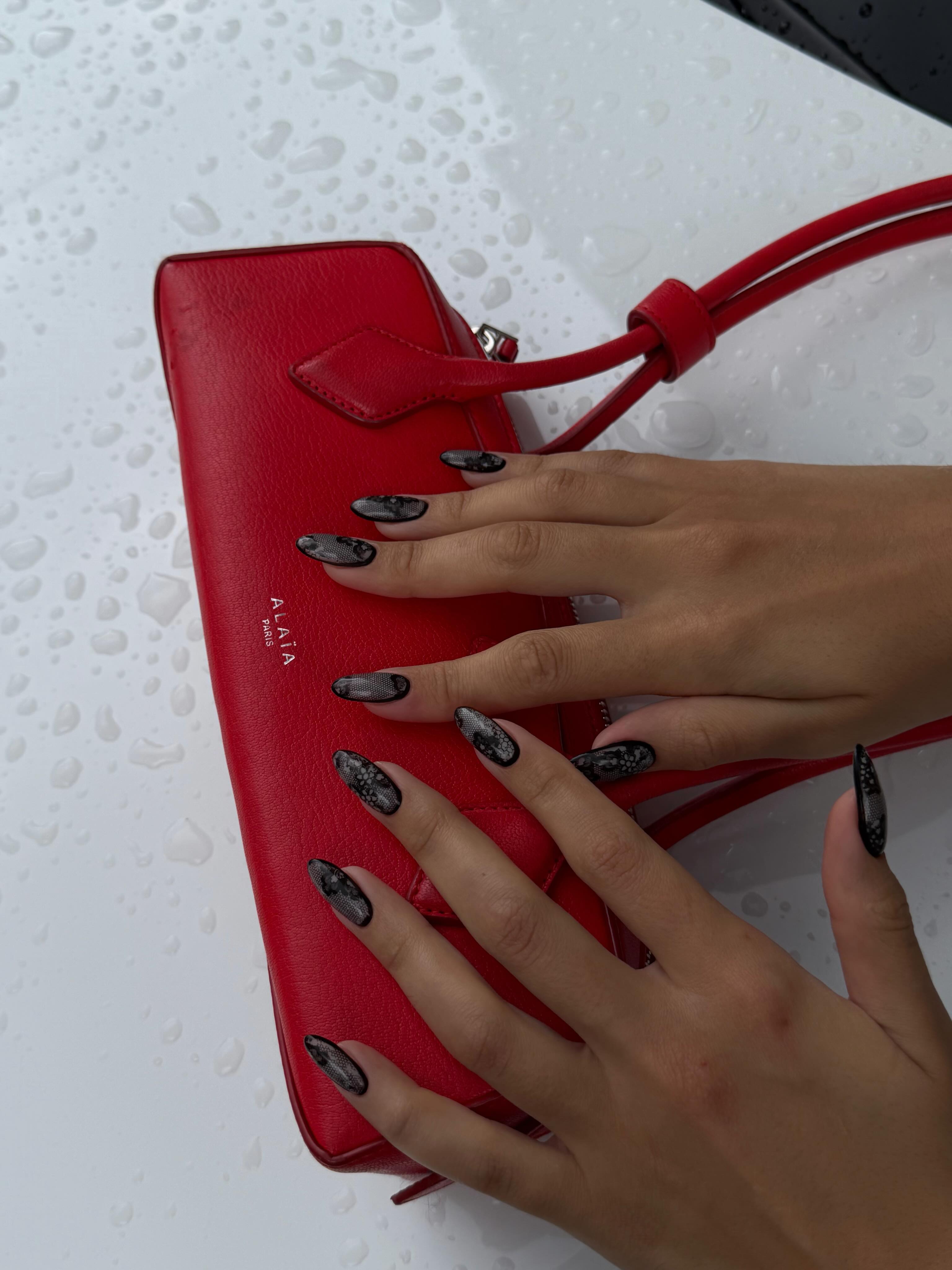 An image of black lace-painted nails.
