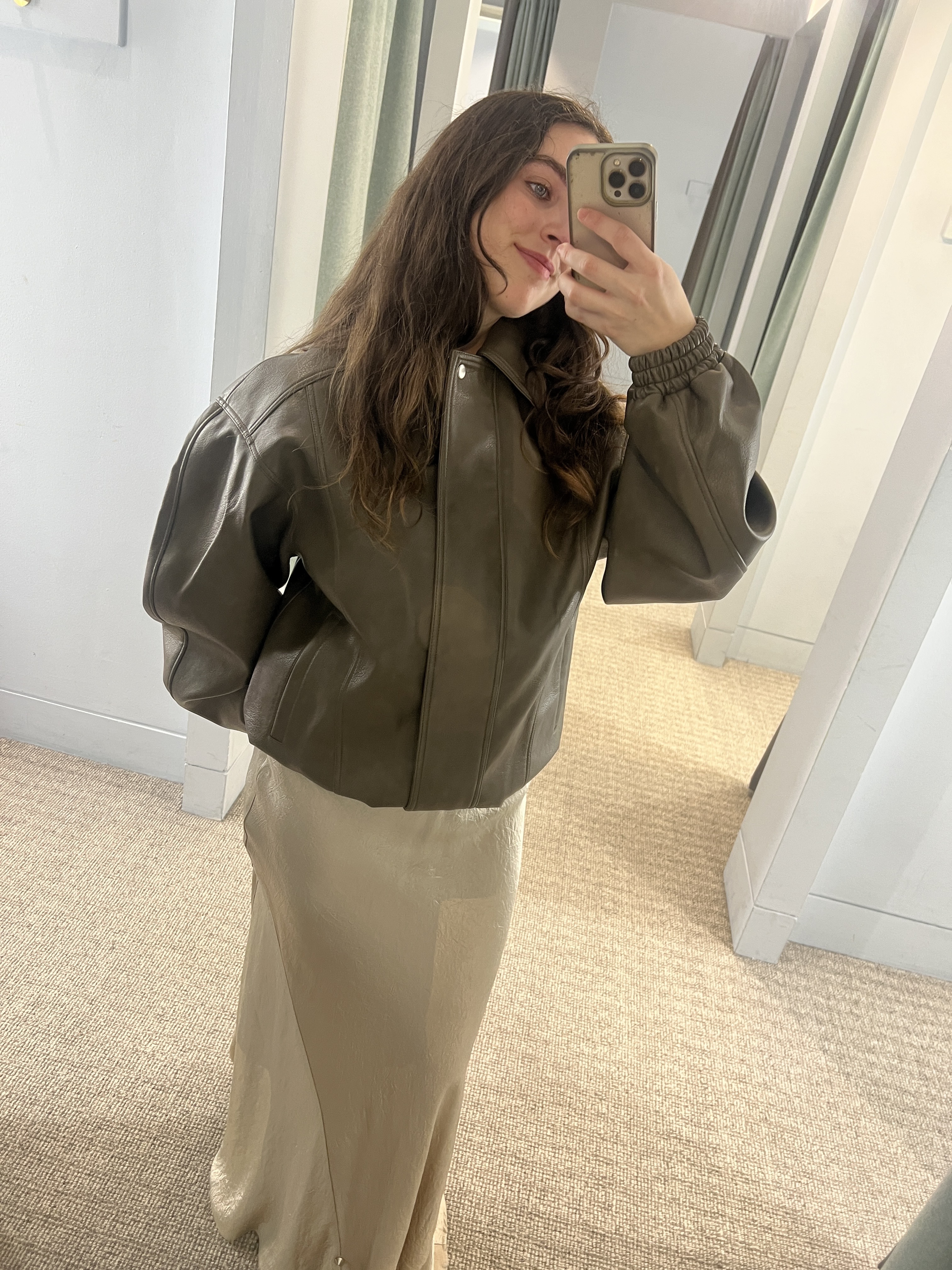 An image of Who What Wear UK's SEO Writer Ava Gilchrist wearing a cream satin skirt from DISSH with a kahki leather bomber.