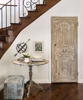 shabby chic entryway with rustic door and vintage side table