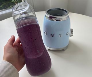 Smeg personal blender smoothie bottle in front of the base