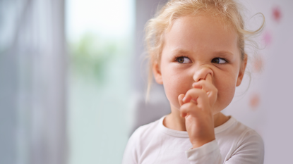 A little girl picking her nose.