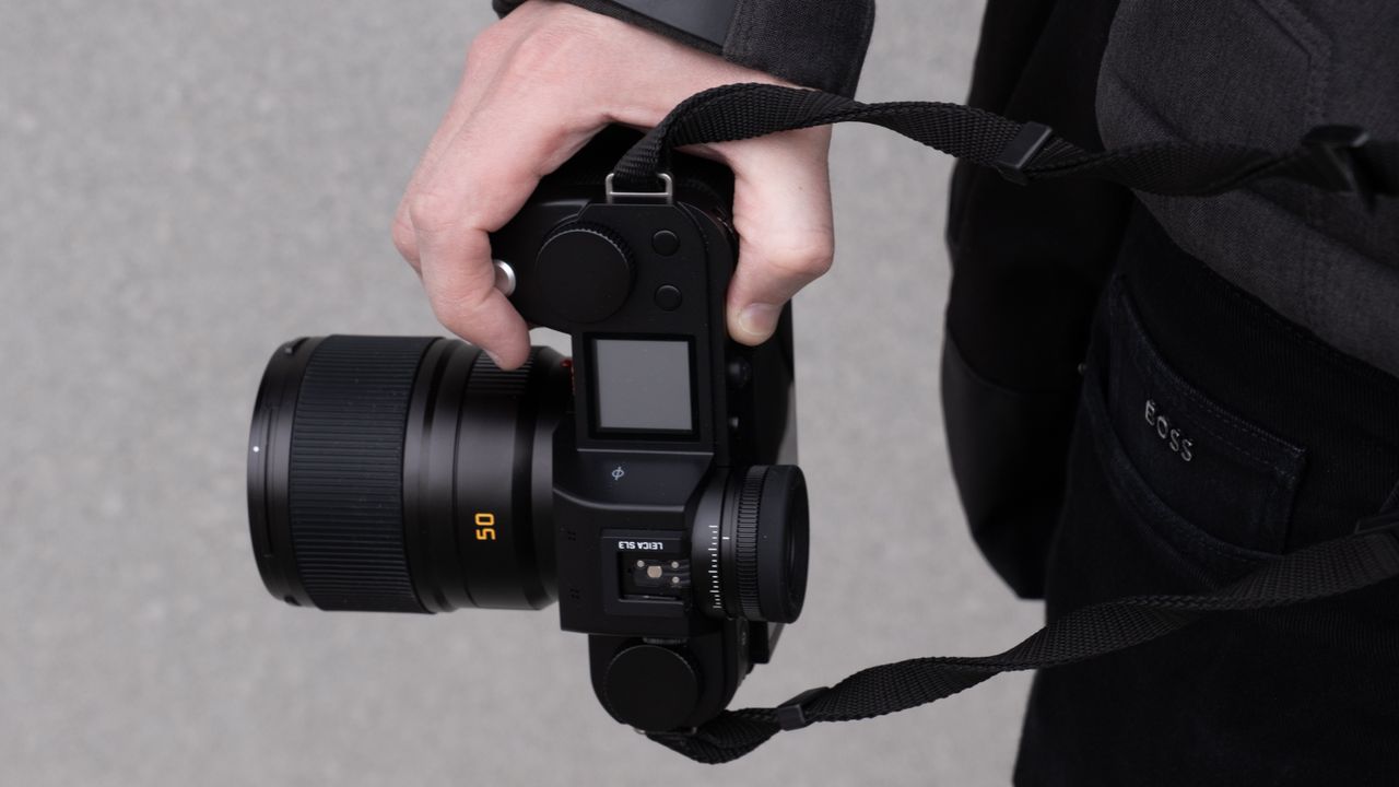 Hands holding the Leica SL3 camera