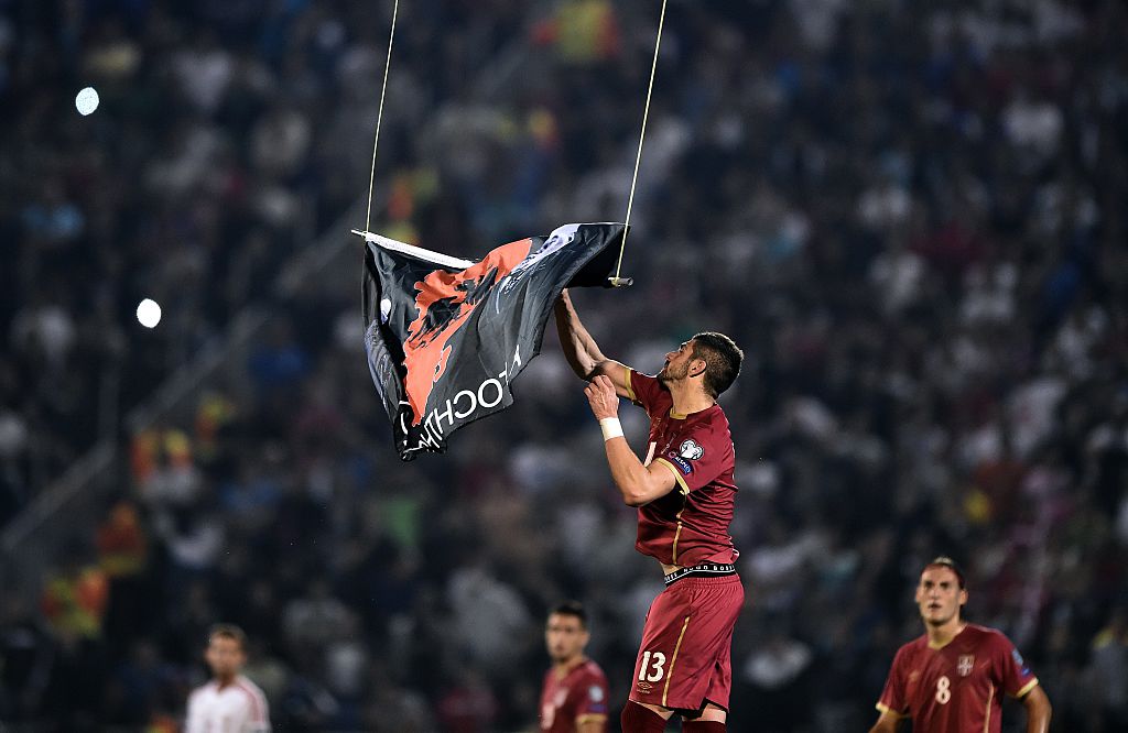 Stefan Mitrovic grabs a flag with Albanian national symbols flown by a remotely operated drone during the abandoned match between Serbia and Albania