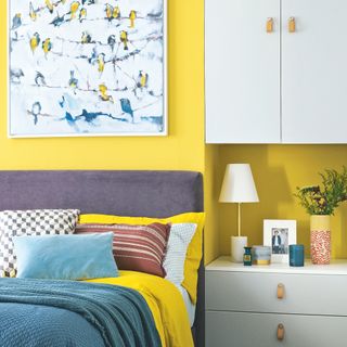 Yellow bedroom with grey headboard and built in storage