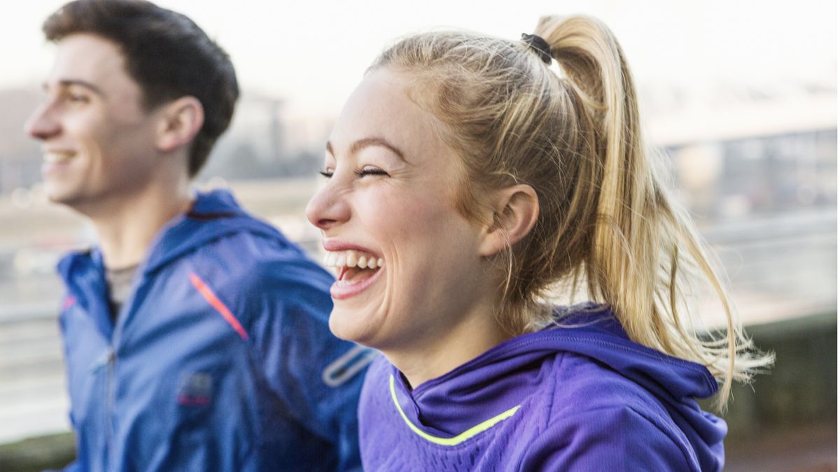 Male and female runners running and laughing