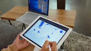 use an iPad as a drawing tablet with a PC; a person draws on tablet computer connected to a laptop