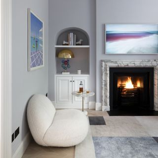 Living room with white sofa and side table with fire on