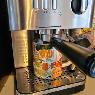 Colorful patterned coffee mug on a silver coffee machine