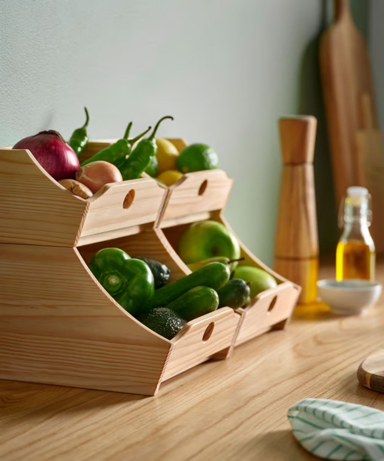 Two sets of IKEA's stacking food boxes in the kitchen, placed side by side on a counter, and packed with vegetables
