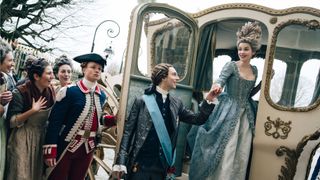 Louis XVI (Louis Cunningham) helps Marie Antoinette (Emilia Schule) out of a carriage