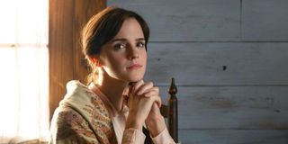 Meg March (Emma Watson) sits with her hands folded under her chin in 'Little Women'
