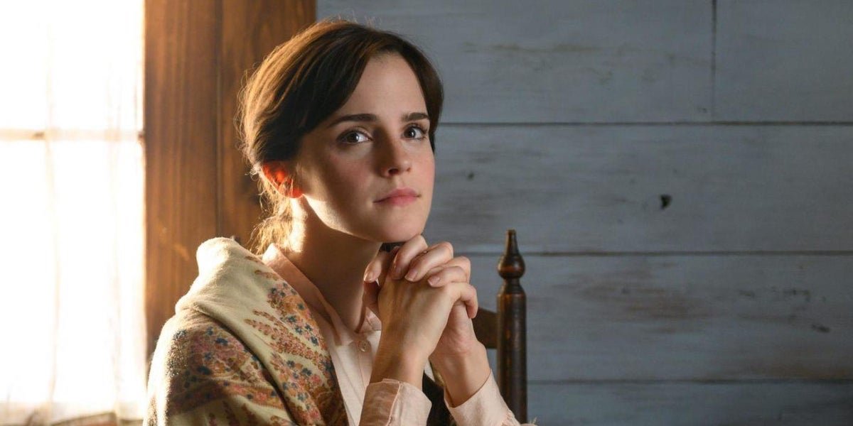 Meg March (Emma Watson) sits with her hands folded under her chin in &#039;Little Women&#039;