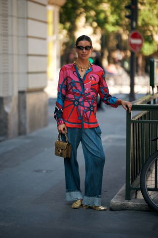 Woman in floral shirt and wide-leg cuffed jeans.