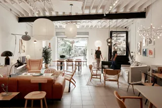 A design showroom is filled with white and wooden-toned furniture.