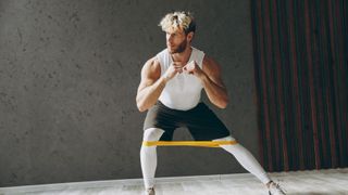 a photo of a man doing the side-stepping exercise with a resistance band