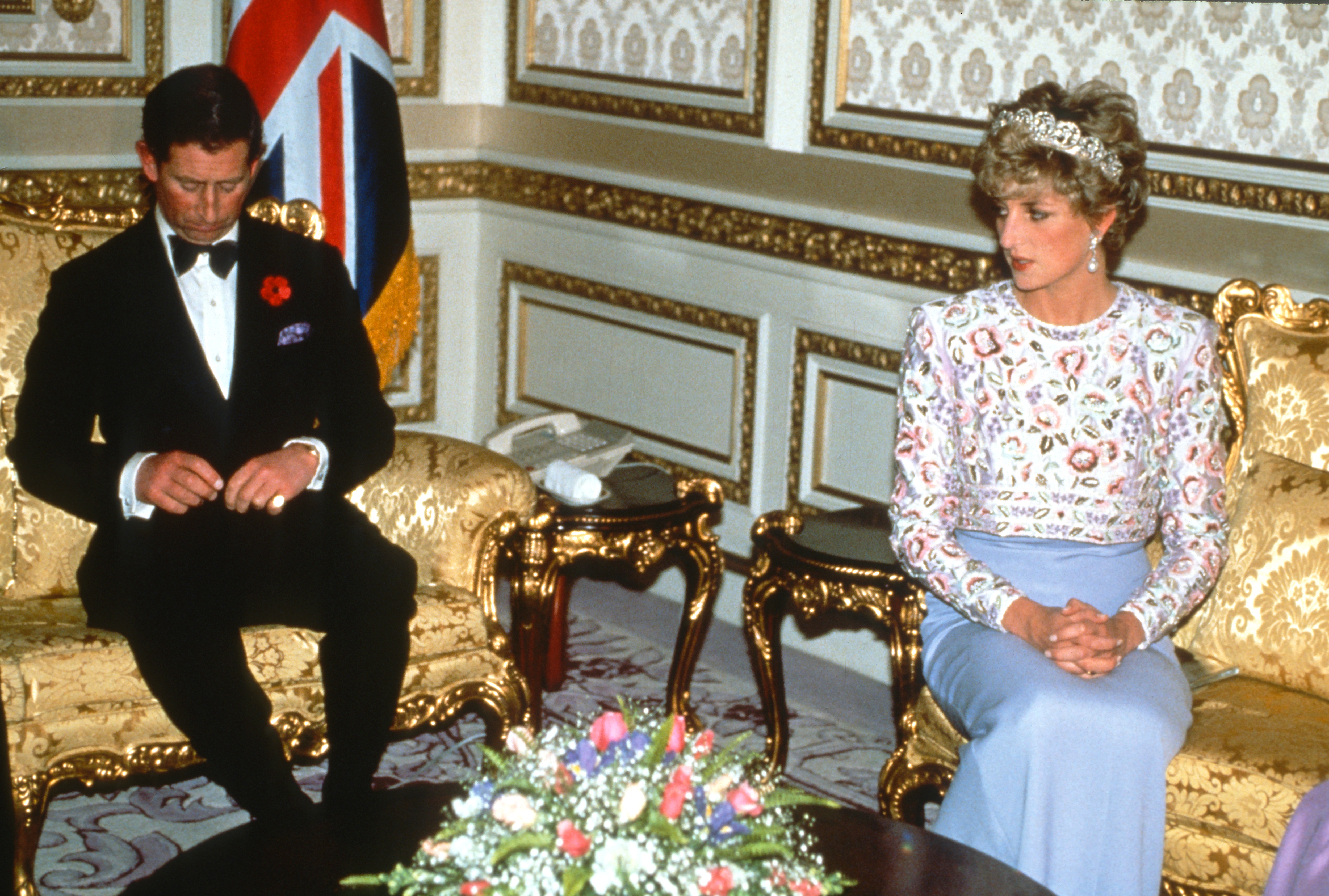 Prince Charles and Princess Diana sitting on gold couches at a state banquet in South Korea