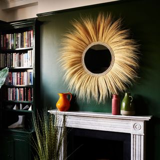 room with fringed mirror on green wall and wooden shelves