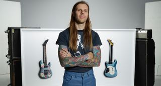 Kane Hibberd, the photographer behind the Scale exhibition in London, poses in front of his photographs – guitars features will include Kerry King of Slayer's BC Rich and Tom Morello's Arm The Homeless S-style.