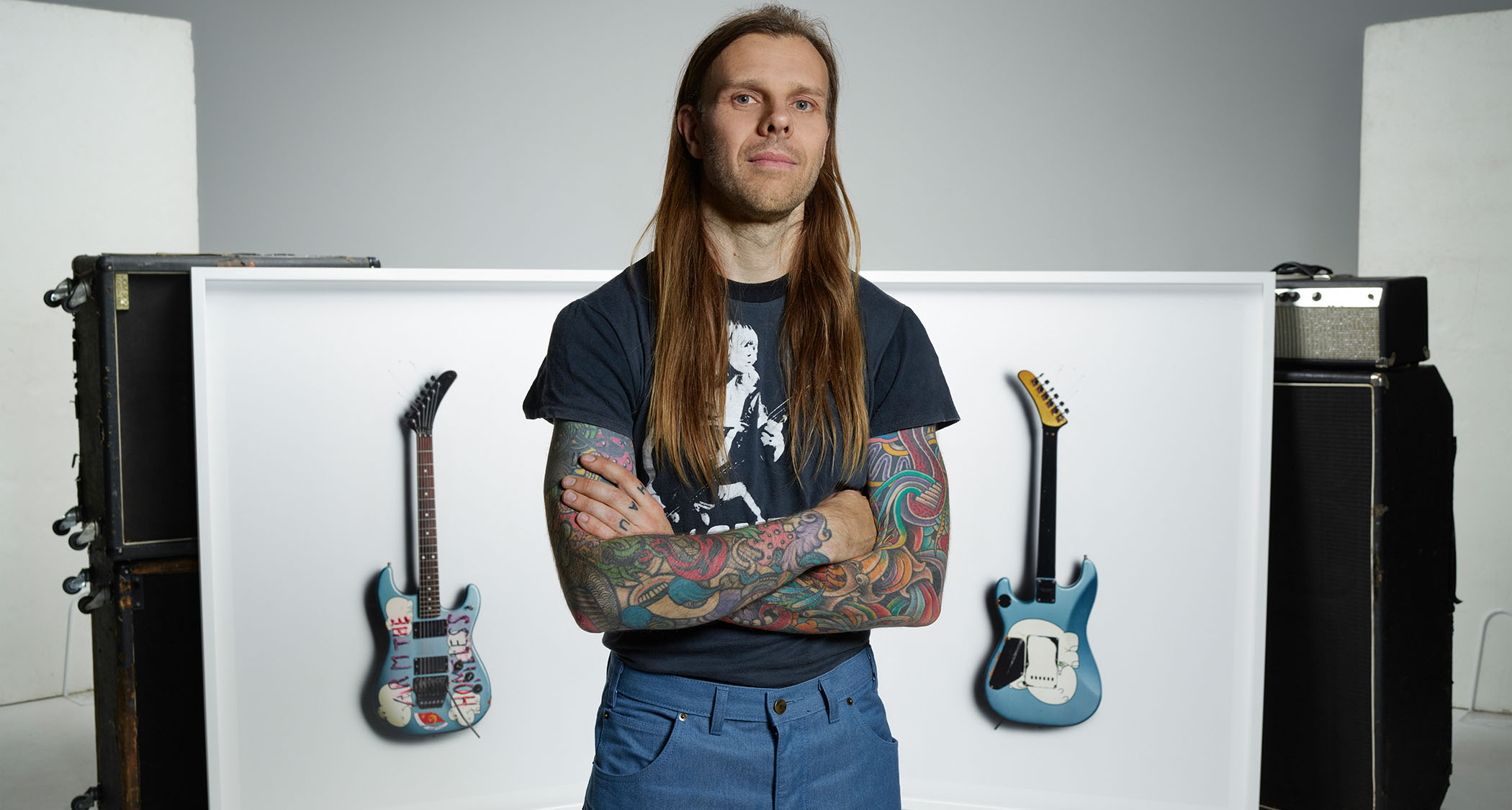 Kane Hibberd, the photographer behind the Scale exhibition in London, poses in front of his photographs – guitars features will include Kerry King of Slayer&#039;s BC Rich and Tom Morello&#039;s Arm The Homeless S-style.