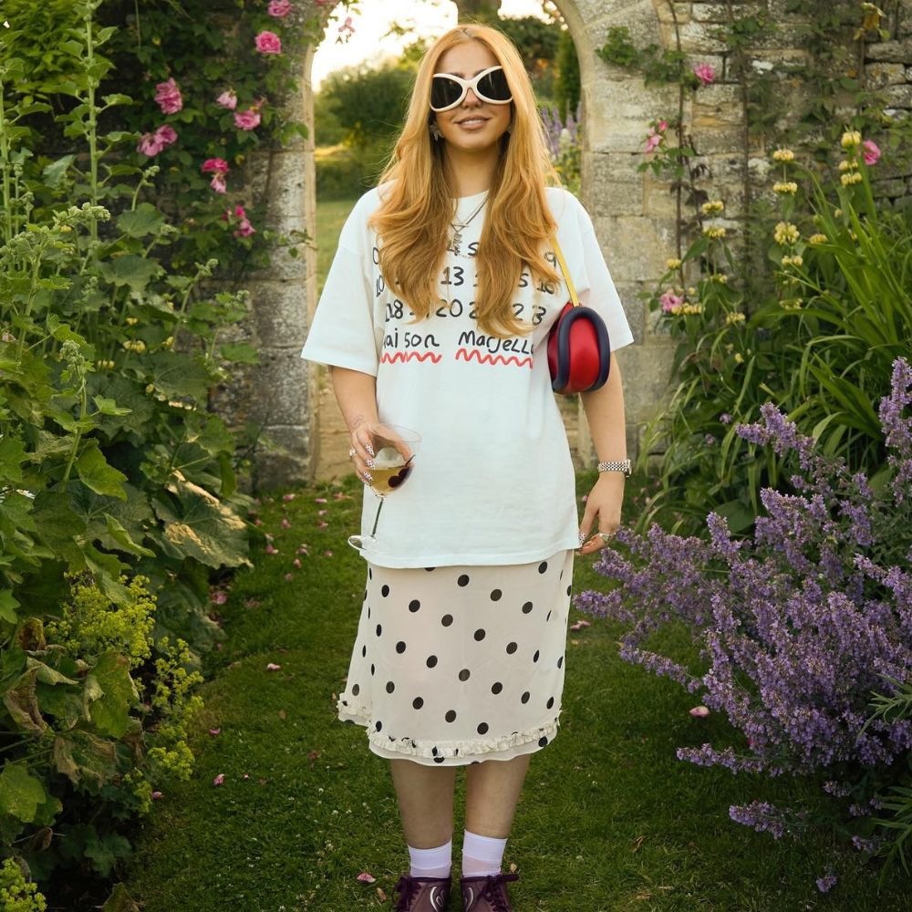 Influencer wears Nike T90 trainers with a polka dot skirt and an oversized t-shirt.