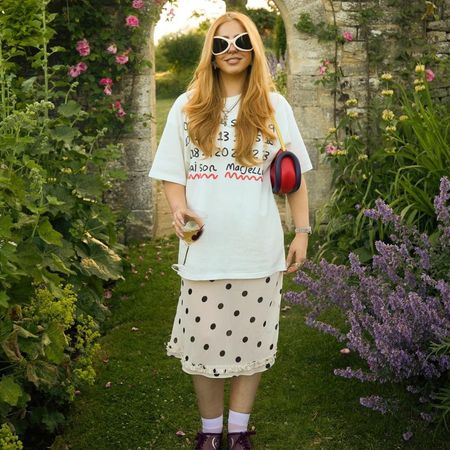 Influencer wears Nike T90 trainers with a polka dot skirt and an oversized t-shirt.