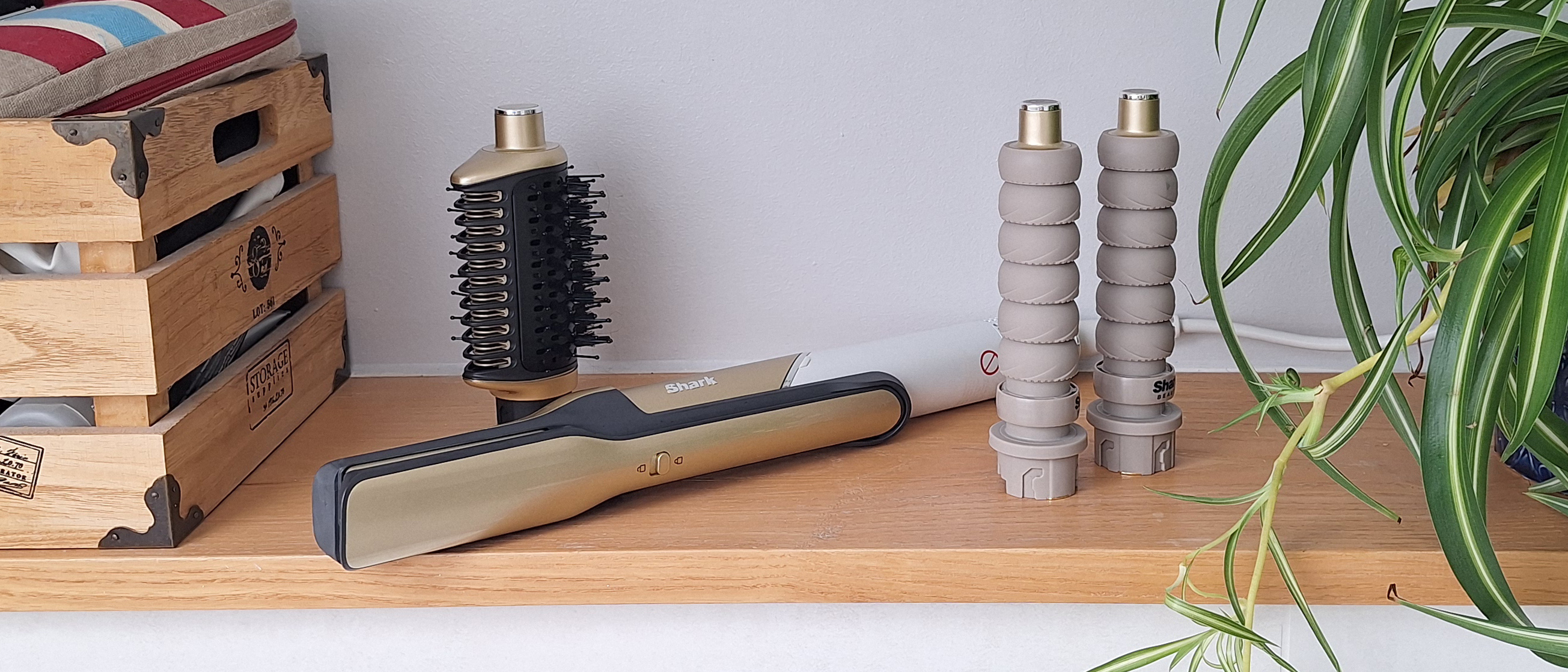 Shark Glam Multi-Styler on a shelf in reviewer&#039;s bathroom, with Silki straightener tool attached, plus curl barrels and Glossi hot brush next to it