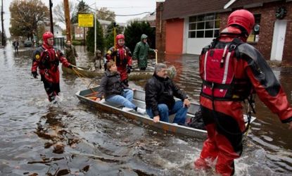 Rescuers bring flood victims out by boat in Little Ferry, N.J., on Oct. 30