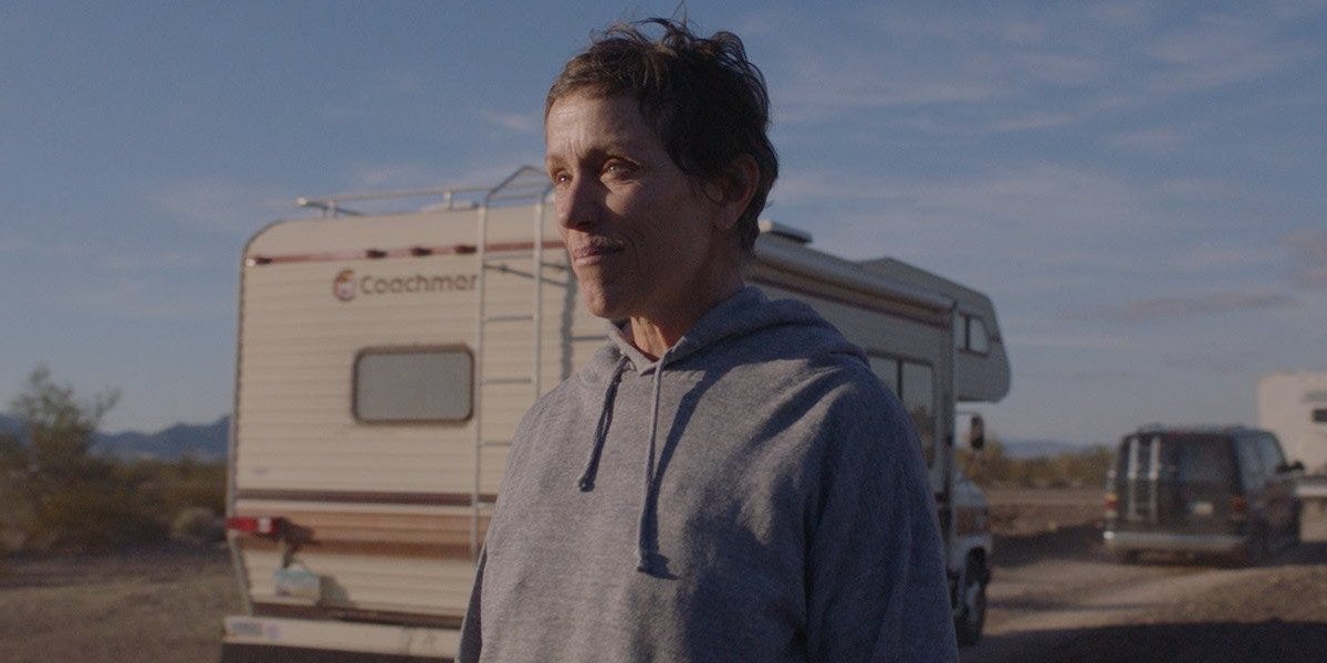 Nomadland Frances McDormand stands alongside a caravan of vehicles