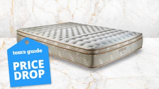 Image shows the Saatva Classic mattress on a white and rose gold marble background with a blue Presidents' Day mattress sales luggage tag badge overlaid on the bottom left hand corner