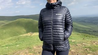 Hiker wearing a blue down jacket with hands in pockets