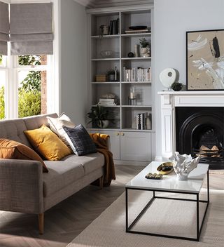 grey living room with brown sofa and built in alcove shelving