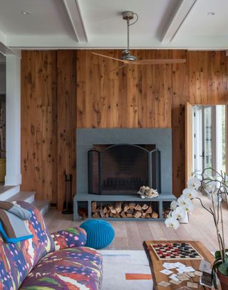 Cozy living room with open fire and wood panelled walls