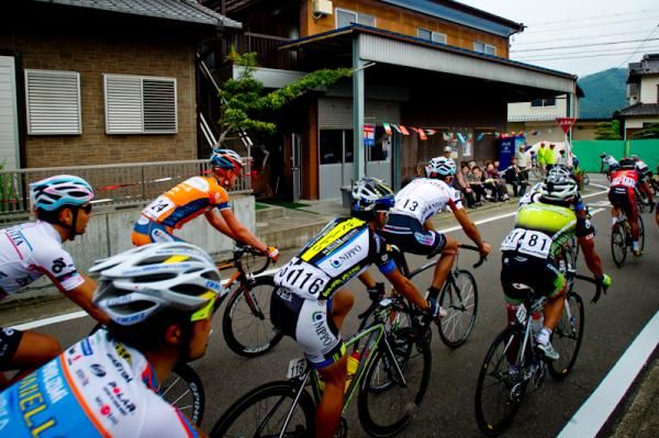 The peloton rolls through a small town during stage 2 at the Tour of Japan