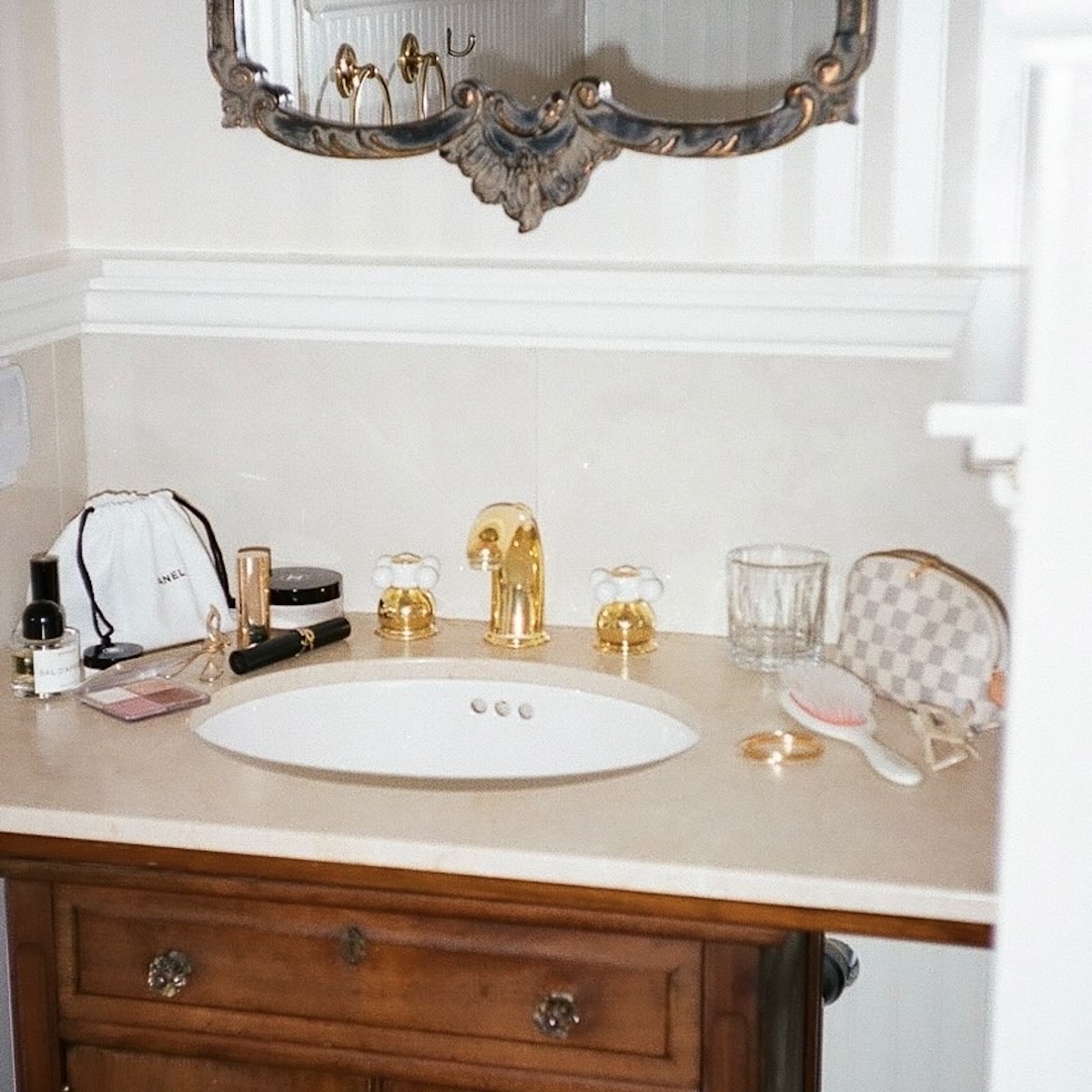 A bathroom vanity with beauty products on top of it