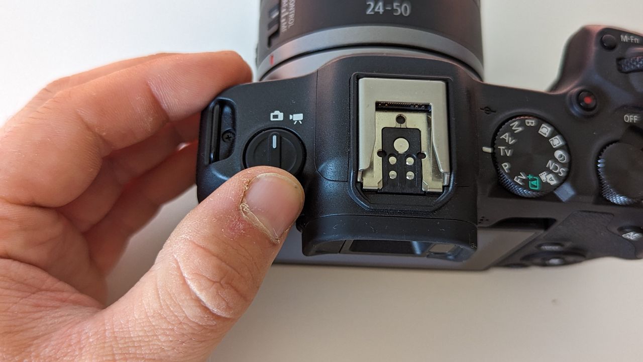 Canon EOS R8 set against a white backdrop with orange glow