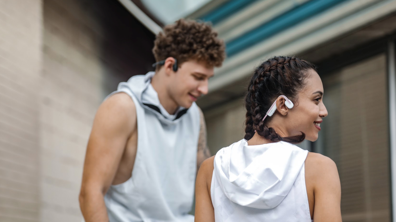 Man and woman wearing Shokz OpenMove headphones