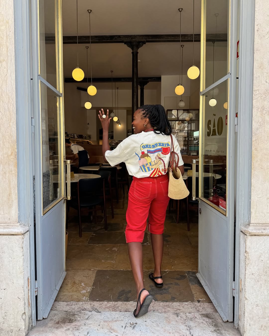 @raquelcostagomess wears red capri pants, graphicT-shirt and basket bag