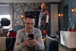 James Nightingale looking at his phone and Ste Hay in background.