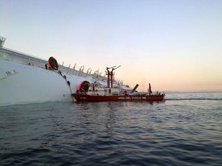 Rescue workers board the sinking Concordia ship.